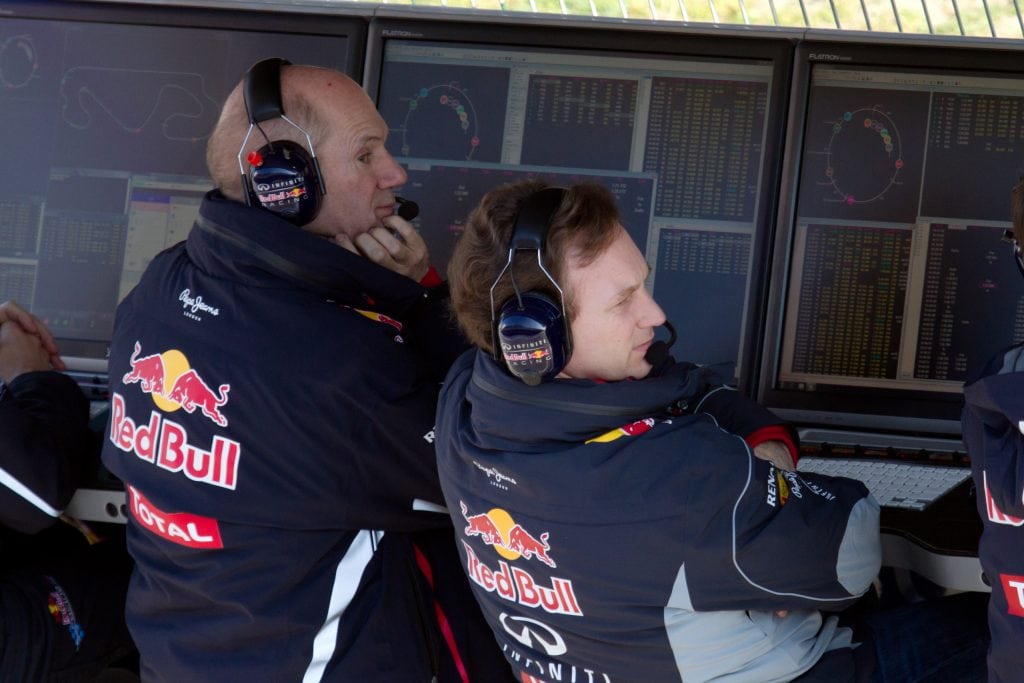 RedBull Formula 1 Team members Adrian Newey and Christian Horner sitting on the pitwall in front of computers.