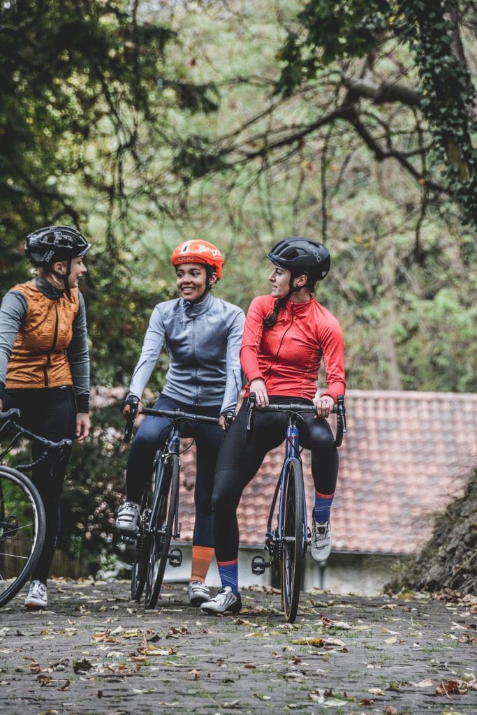 Three woman on road bikes chatting.