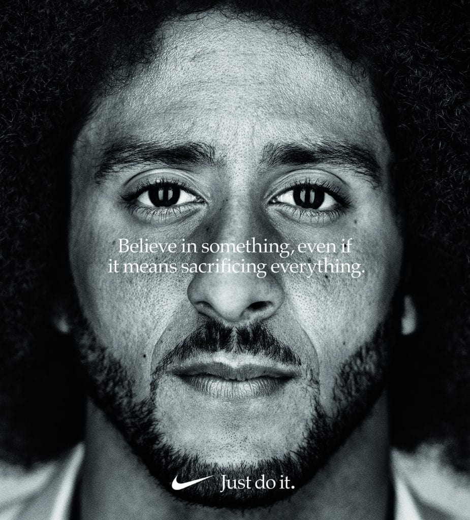 Nike advert showing the face of American football player Colin Kaepernick with the words 'Believe in something, even if it means sacrificing everything' written over his face.
