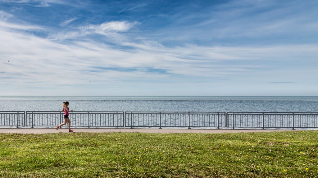 Woman jogging along the seafront. 