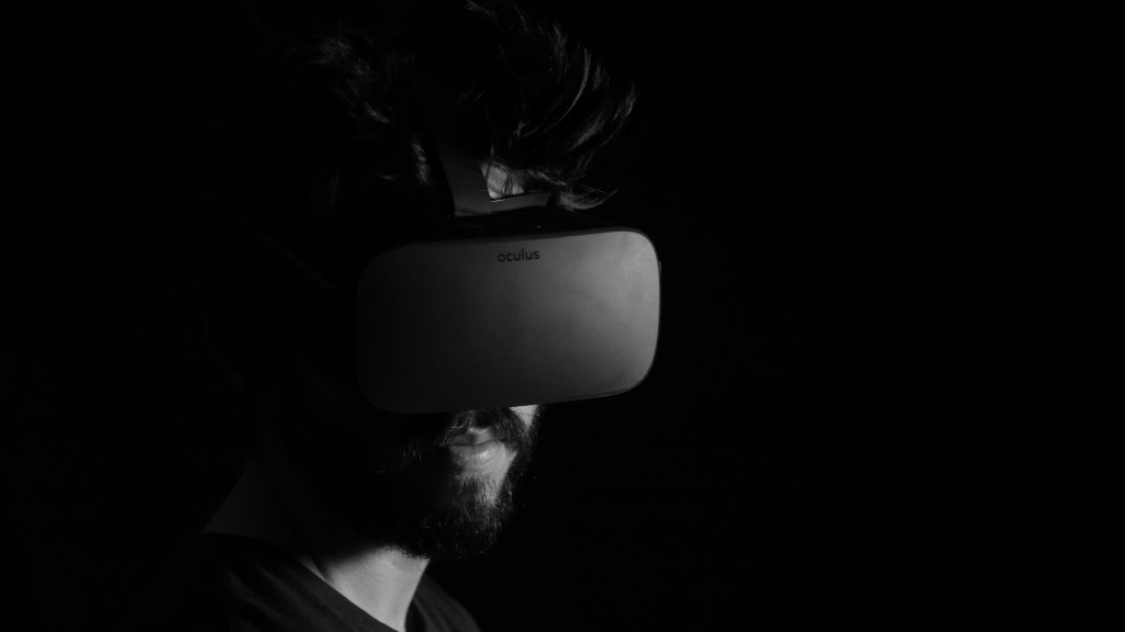 Black and white image of a man wearing a virtual reality headset.