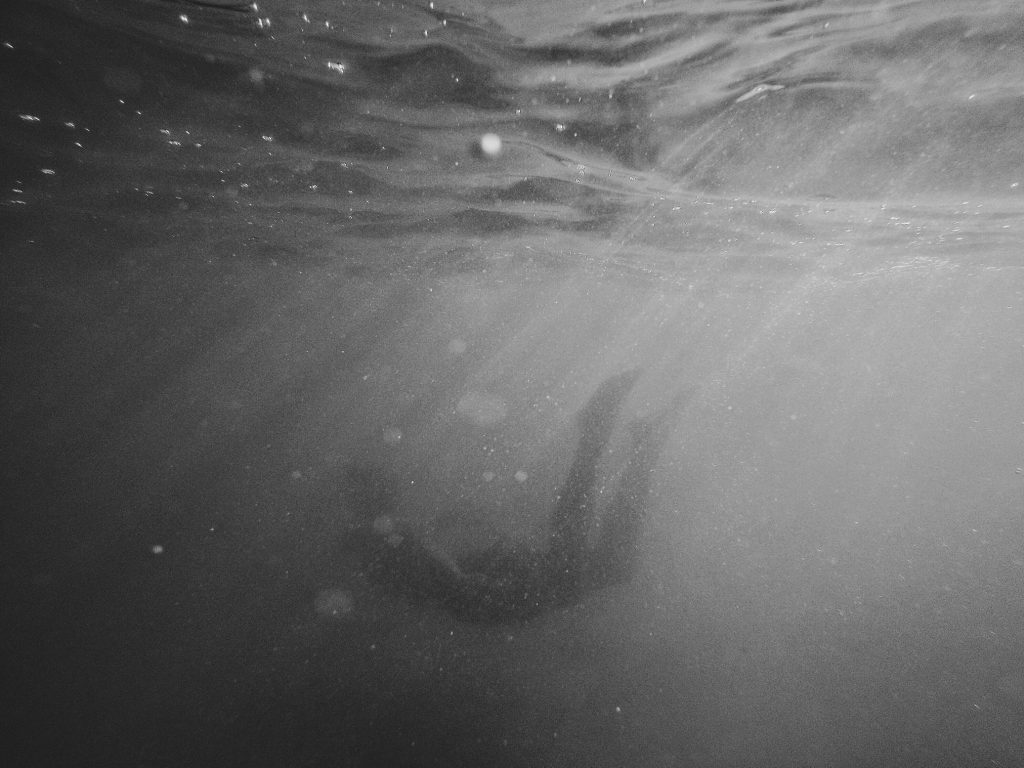 Person swimming underwater.
