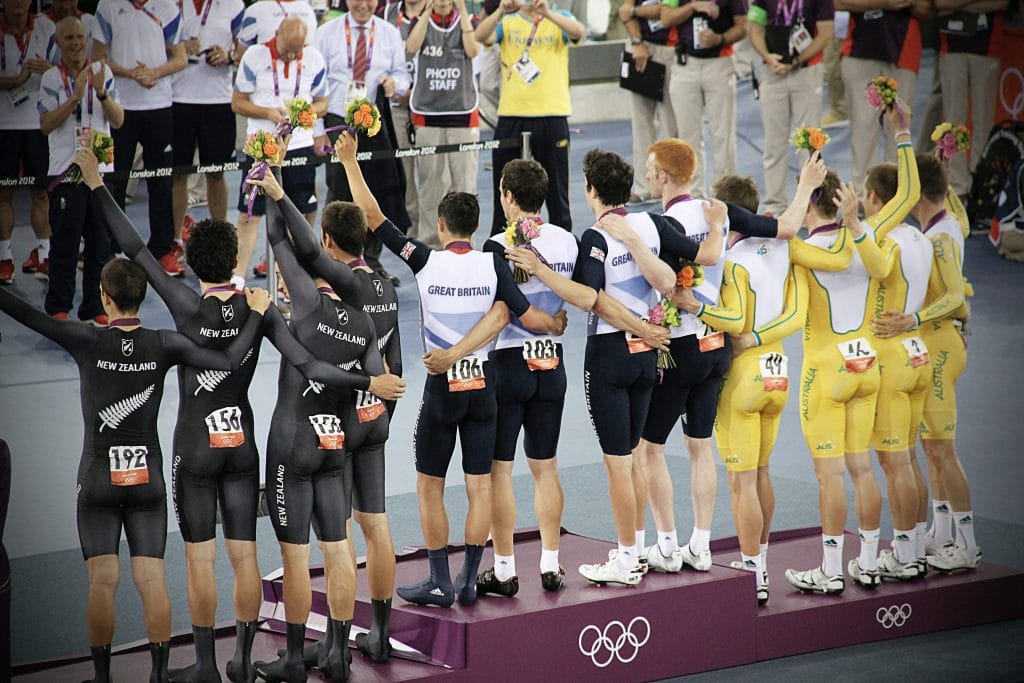 Groups of male cyclists standing on podium.
