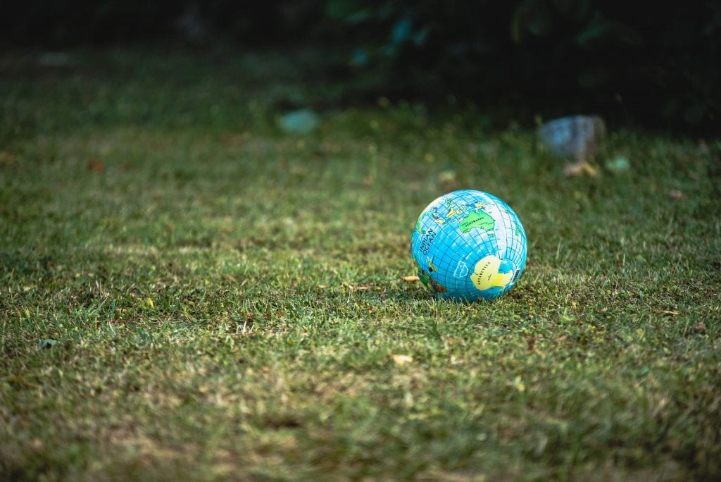 Inflatable globe of Earth lying on the grass.
