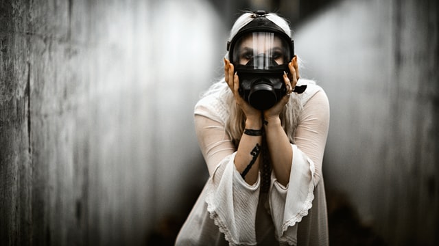 Woman wearing a full gas mask in public.