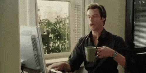 Gif of Jim Carrey drinking coffee and typing on a keyboard.
