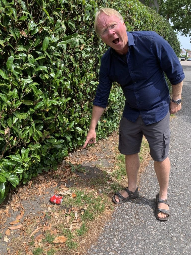The author of the article pointing in anger at a littered can on the sidewalk.