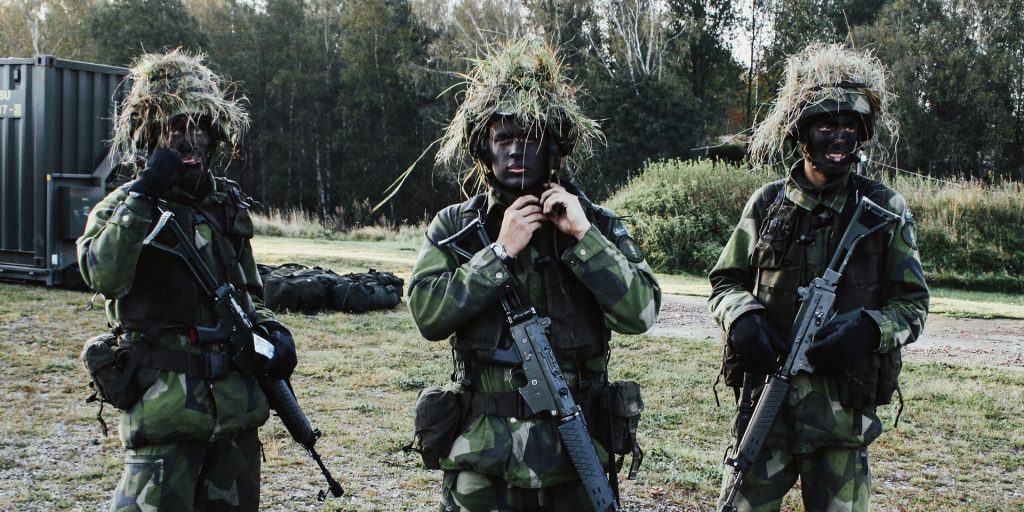 Three soldiers in heavy camouflage. 