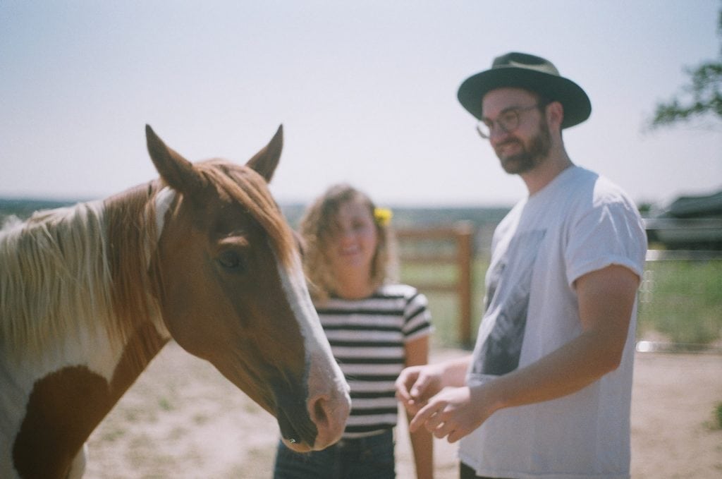 Man and woman interacting with a horse.