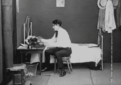 Gif from an old black and white movie of a man throwing a typewriter in anger.