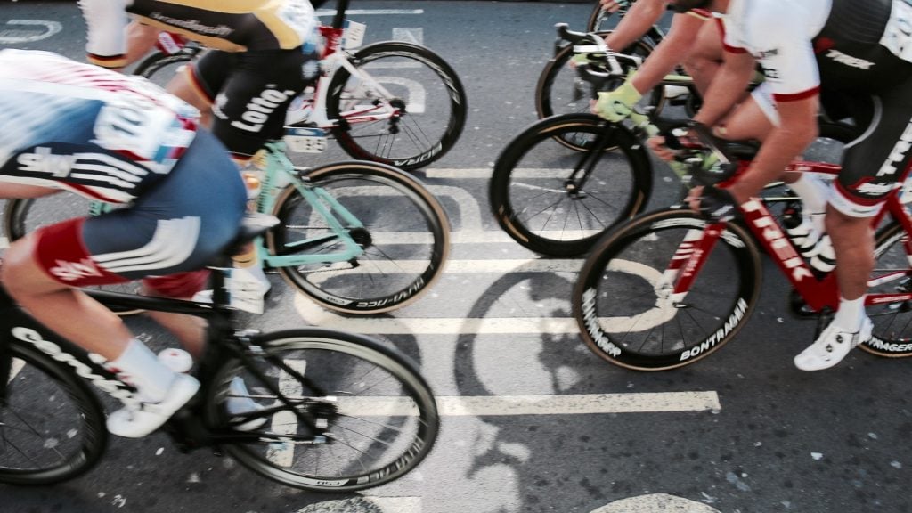 Shot of wheels and legs of cyclists at speed.
