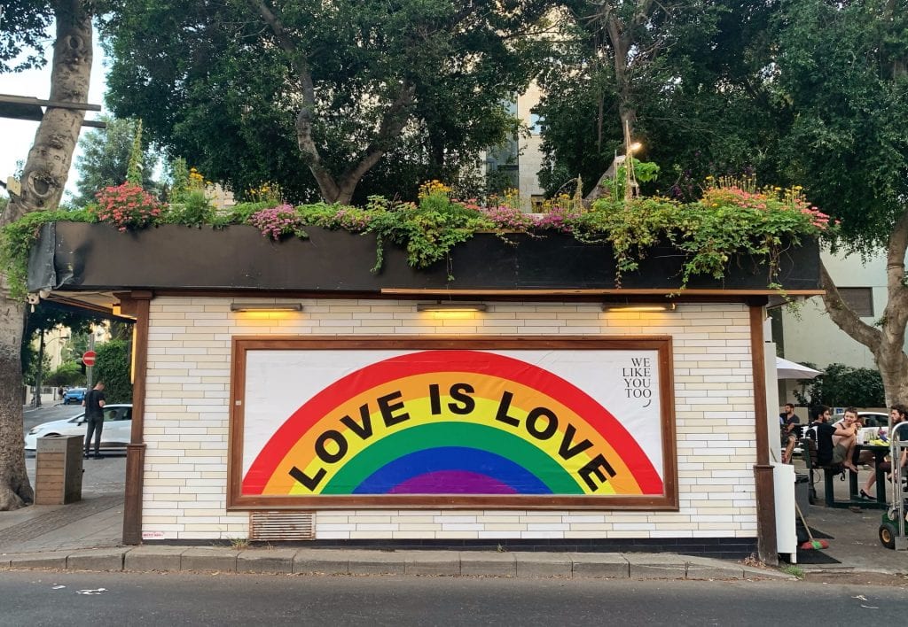 Wall painted with rainbow and the words 'Love is Love'.