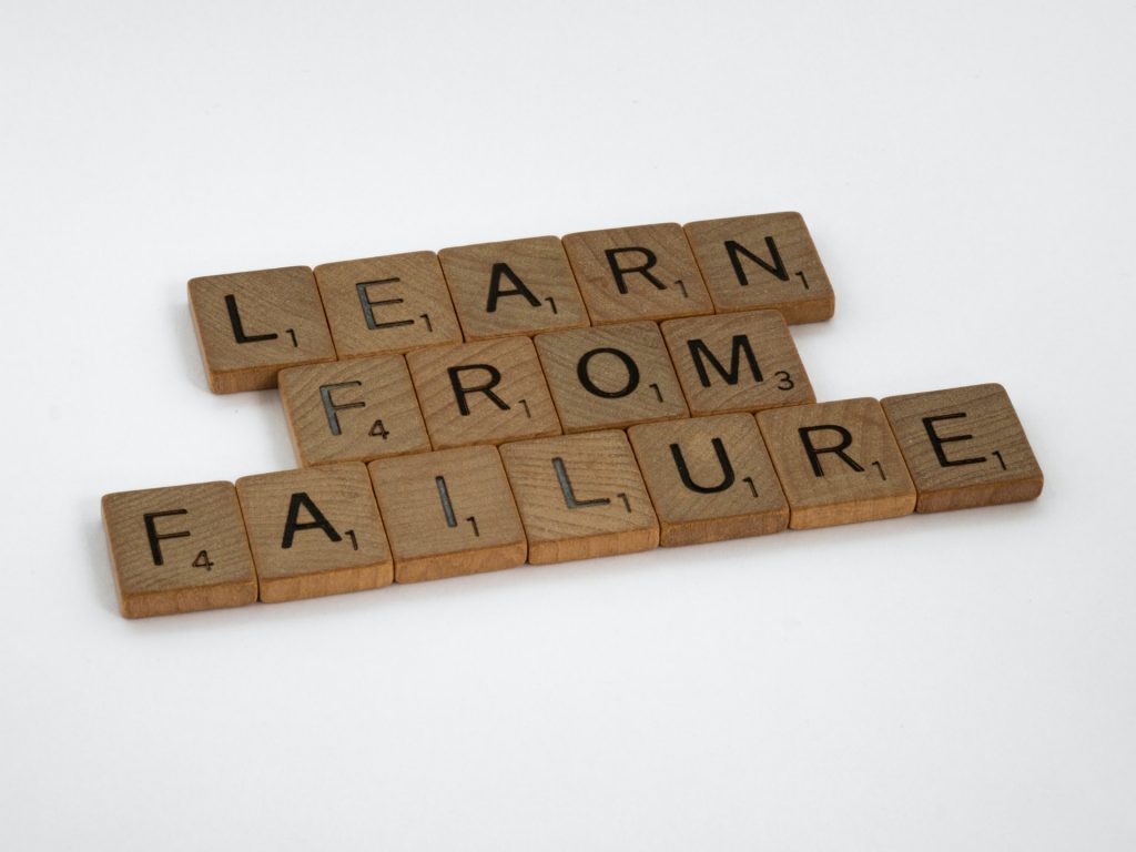 Wooden Scrabble letters spelling out the phrase 'Learn From Failure'.