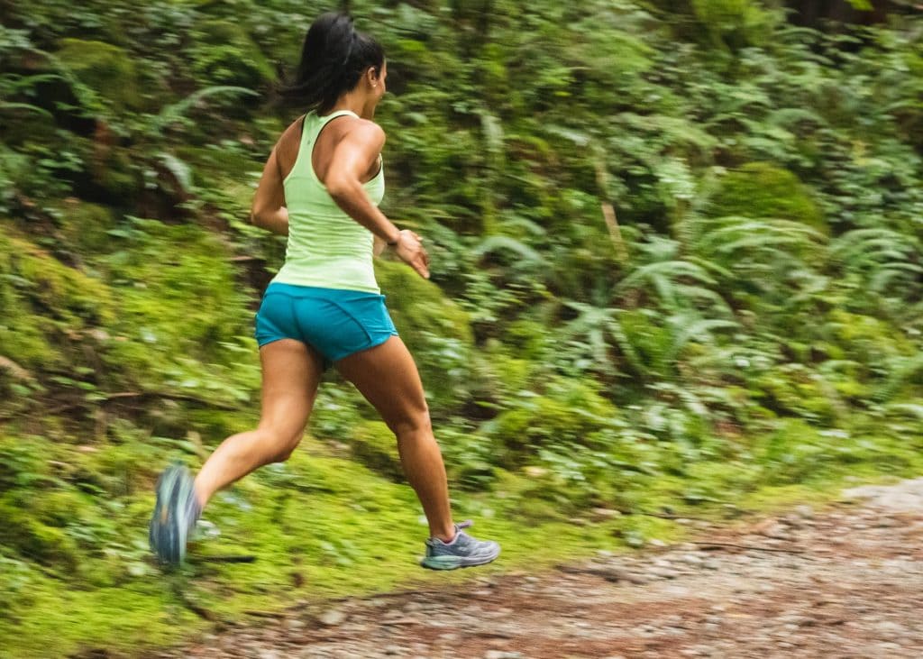 Woman jogging on nature trail.
