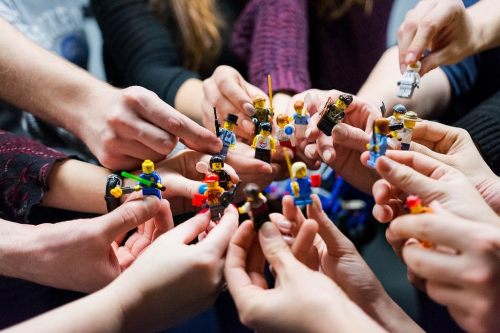 several hands holding lego figures