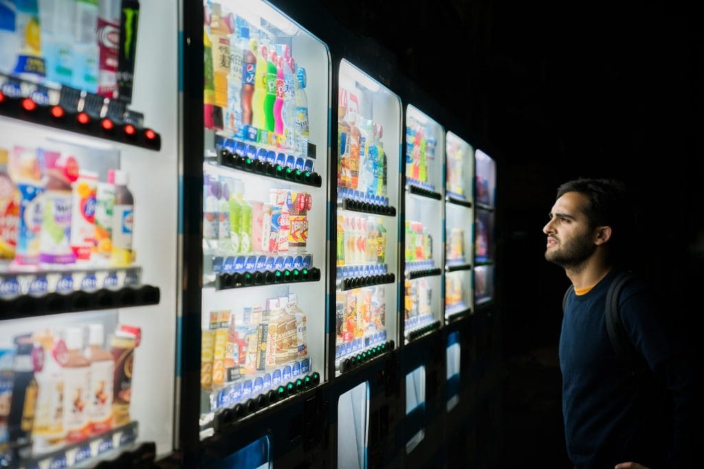 man standing in front of vast vending machine