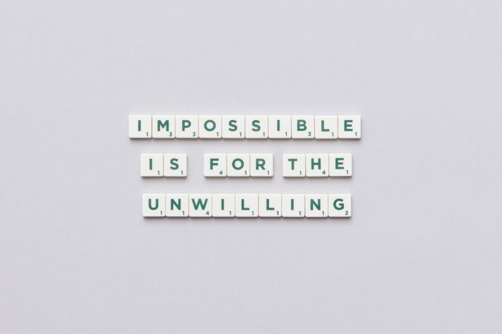 scrabble tiles arranged to say 'impossible is the unwilling'